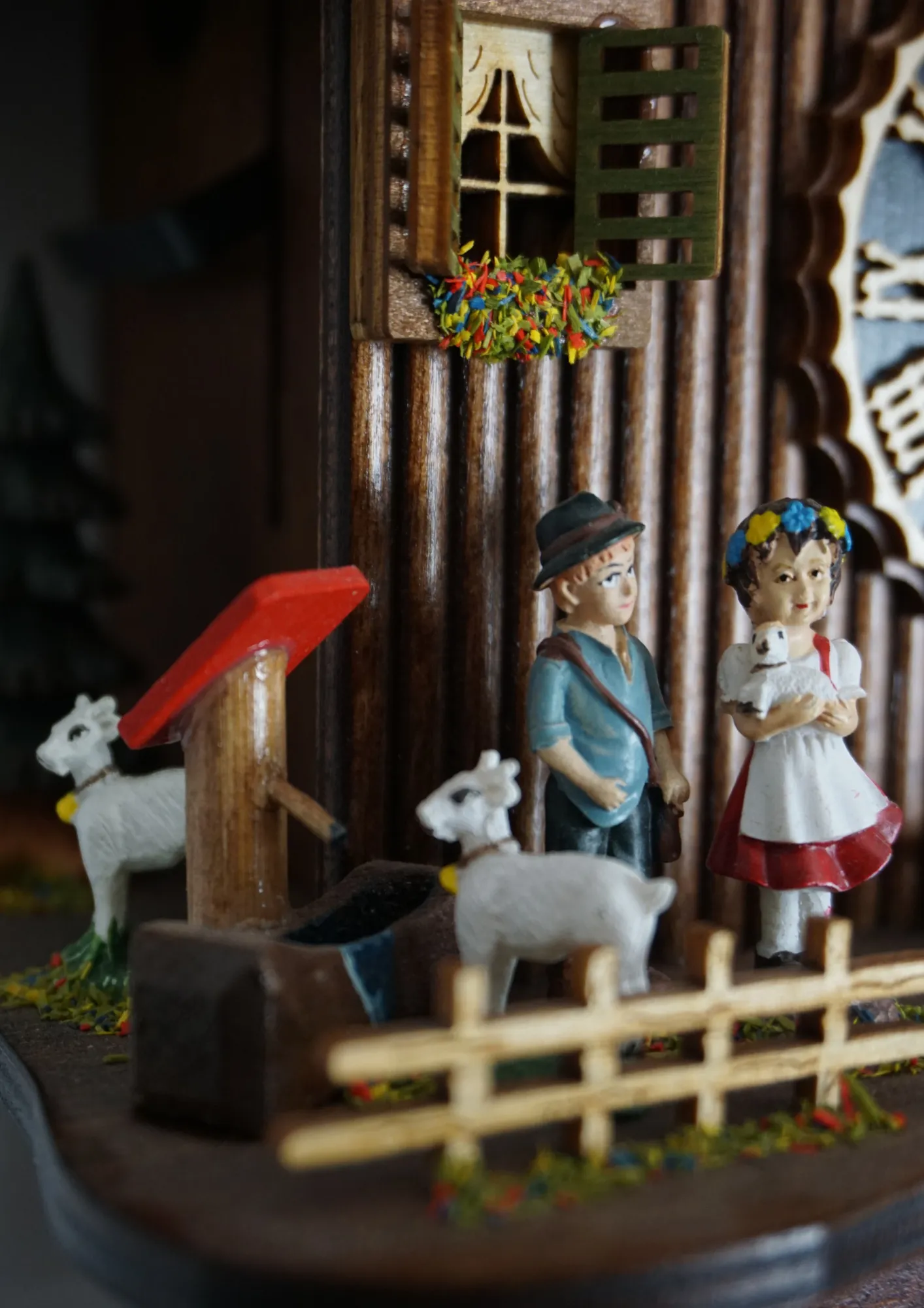 8 day mechanical black forest cuckoo clock in brown color with colorful figures from Heidi storyline, Heidi, grandpa and Peter are standing in front of the clock named Heidi House. Made by Hönes