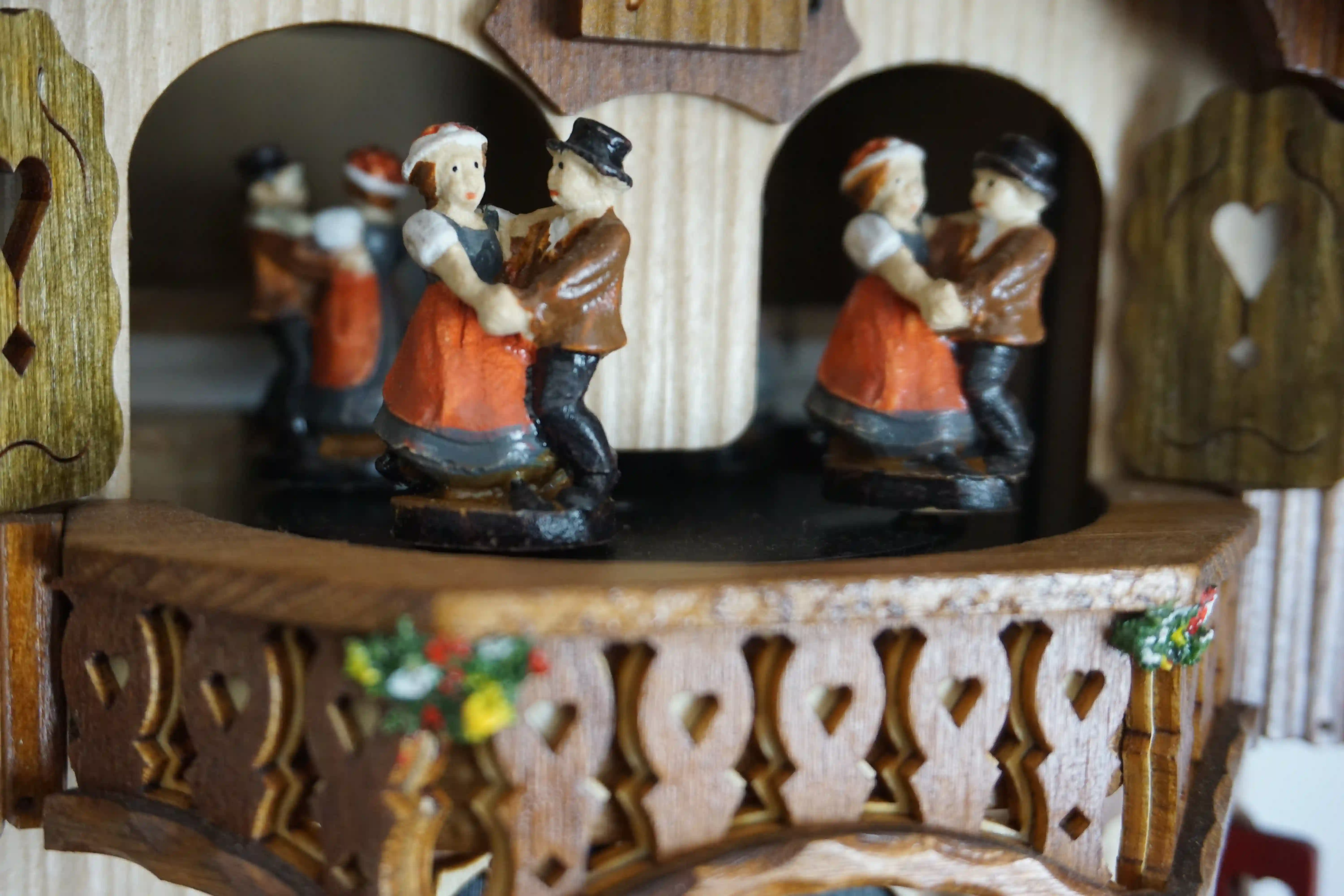 Cuckoo Clock  Wood Chopper  1 Day Movement with Music (5) chalet authentic black forest cuckoo clock with a red shingle roof and a wood chopper, as the music plays dancers dance, wood is being chopped and the water wheel turns, the clock is made by Hönes