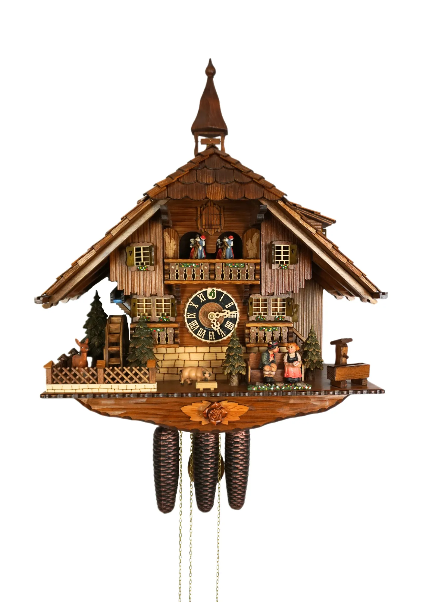 Large authentic chalet colorful black forest cuckoo clocks decorated to the finest detail. Represents a black forest couple on their honeymoon sitting on the bench in front of the shingle roof house. As the music plays the couple is kissing, water wheel t