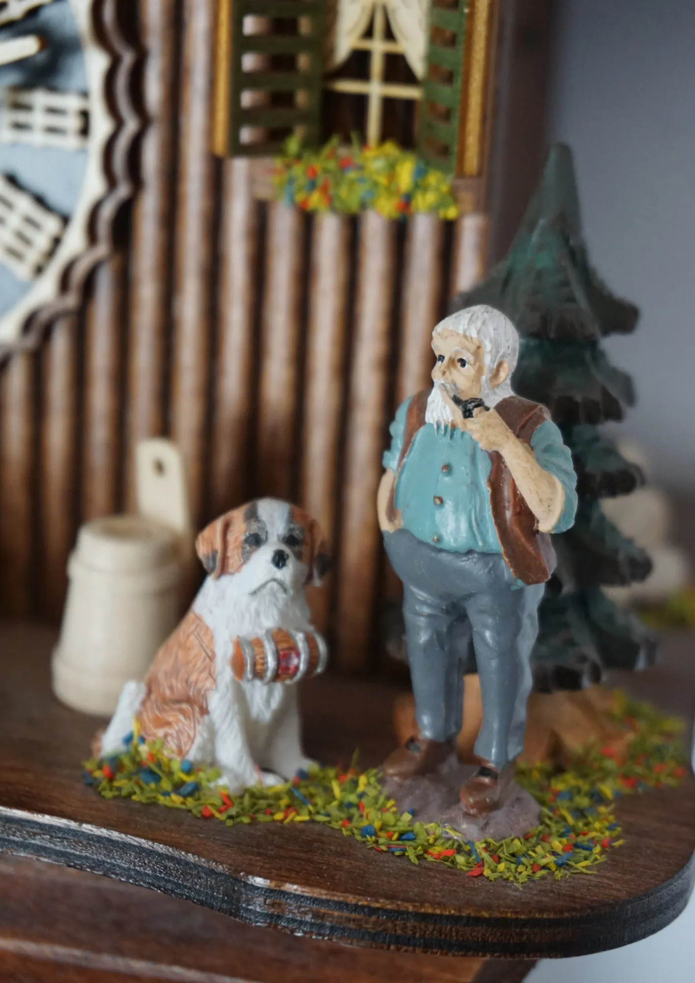 Cuckoo Clock  Heidi House  8 Day Movement (3) 8 day mechanical black forest cuckoo clock in brown color with colorful figures from Heidi storyline, Heidi, grandpa and Peter are standing in front of the clock named Heidi House. Made by Hönes