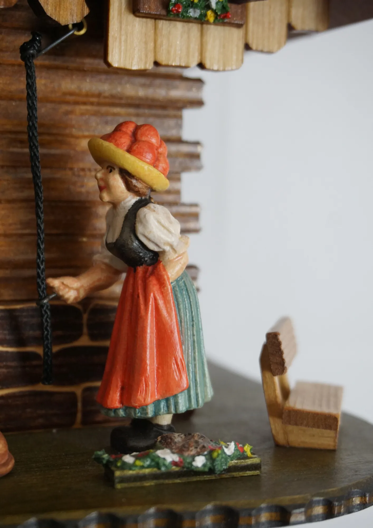 Cuckoo Clock  Bell Ringer Small  1 Day Movement with Music (3) Chalet style authentic mechanical black forest cuckoo clock with shingle roof, church tower bell and black forest lady wearing traditional clothing, the lady rings the bell together with the cuckoo sound, music plays and water wheel turns. This clock has