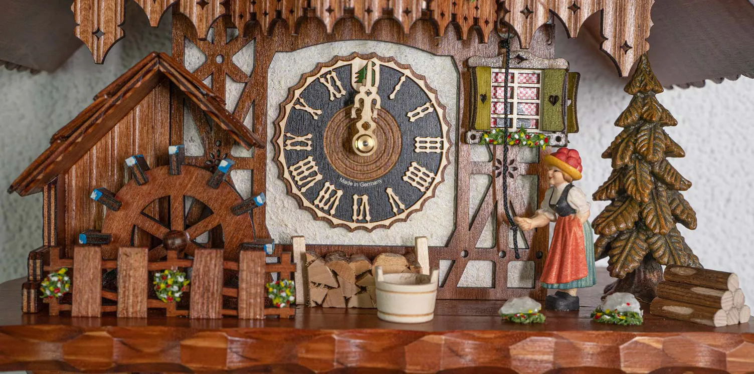 Cuckoo Clock  Bell Ringer, Cottage House  1 Day Movement  Music (5) Cottage brown-white mechanical black forest cuckoo clock with black forest lady in traditional dress with bollenhut ringing the house bell, while music is being played dancers dance and water wheel turn. made by Hönes