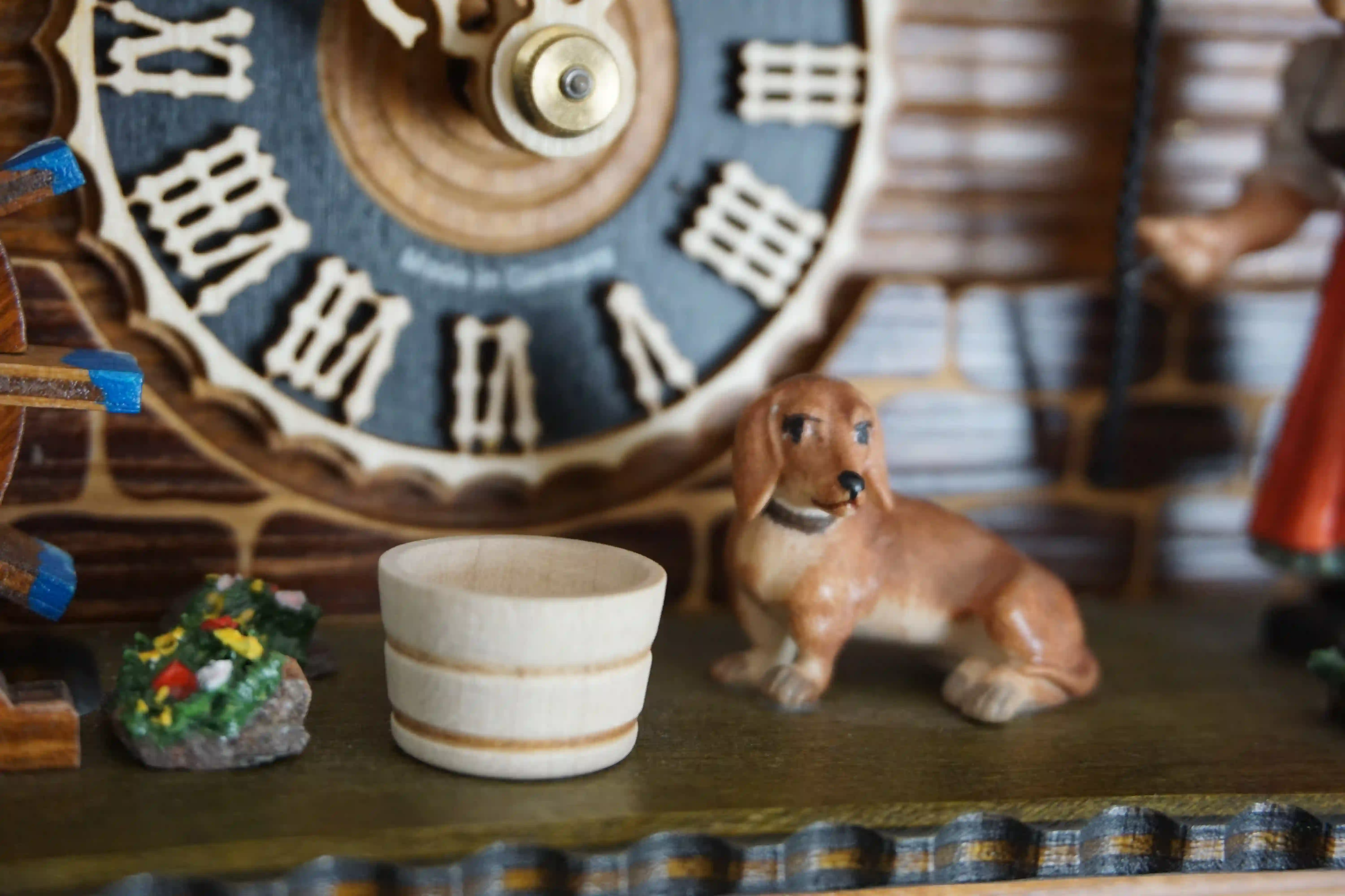 Cuckoo Clock  Bell Ringer Small  1 Day Movement with Music (7) Chalet style authentic mechanical black forest cuckoo clock with shingle roof, church tower bell and black forest lady wearing traditional clothing, the lady rings the bell together with the cuckoo sound, music plays and water wheel turns. This clock has