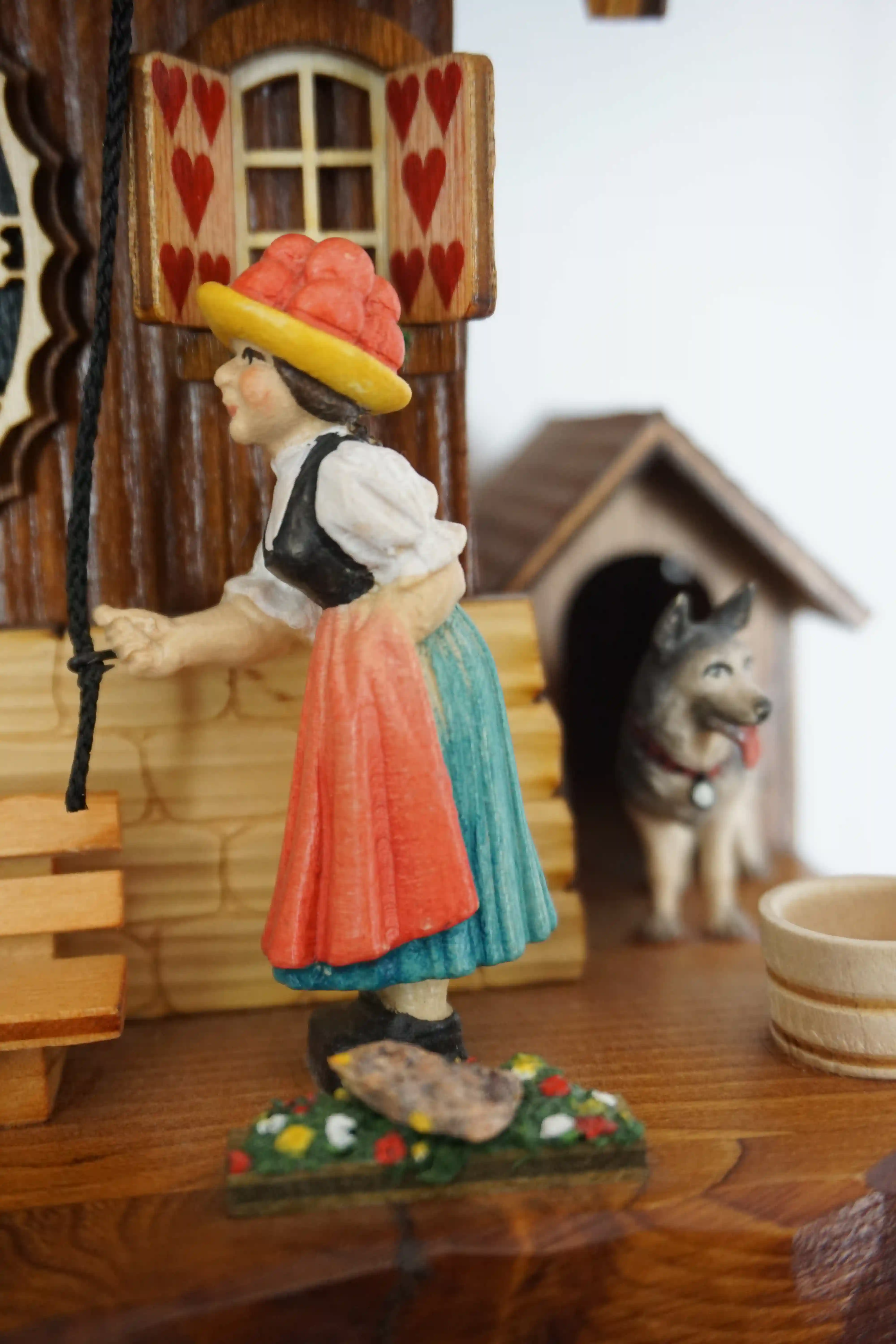 Cuckoo Clock  Bell Ringer  1 Day Movement  Music (4) Chalet style authentic mechanical black forest cuckoo clock with shingle roof, church tower bell and black forest lady wearing traditional clothing, the lady rings the bell together with the cuckoo sound, music plays dancers dance and water wheel turns