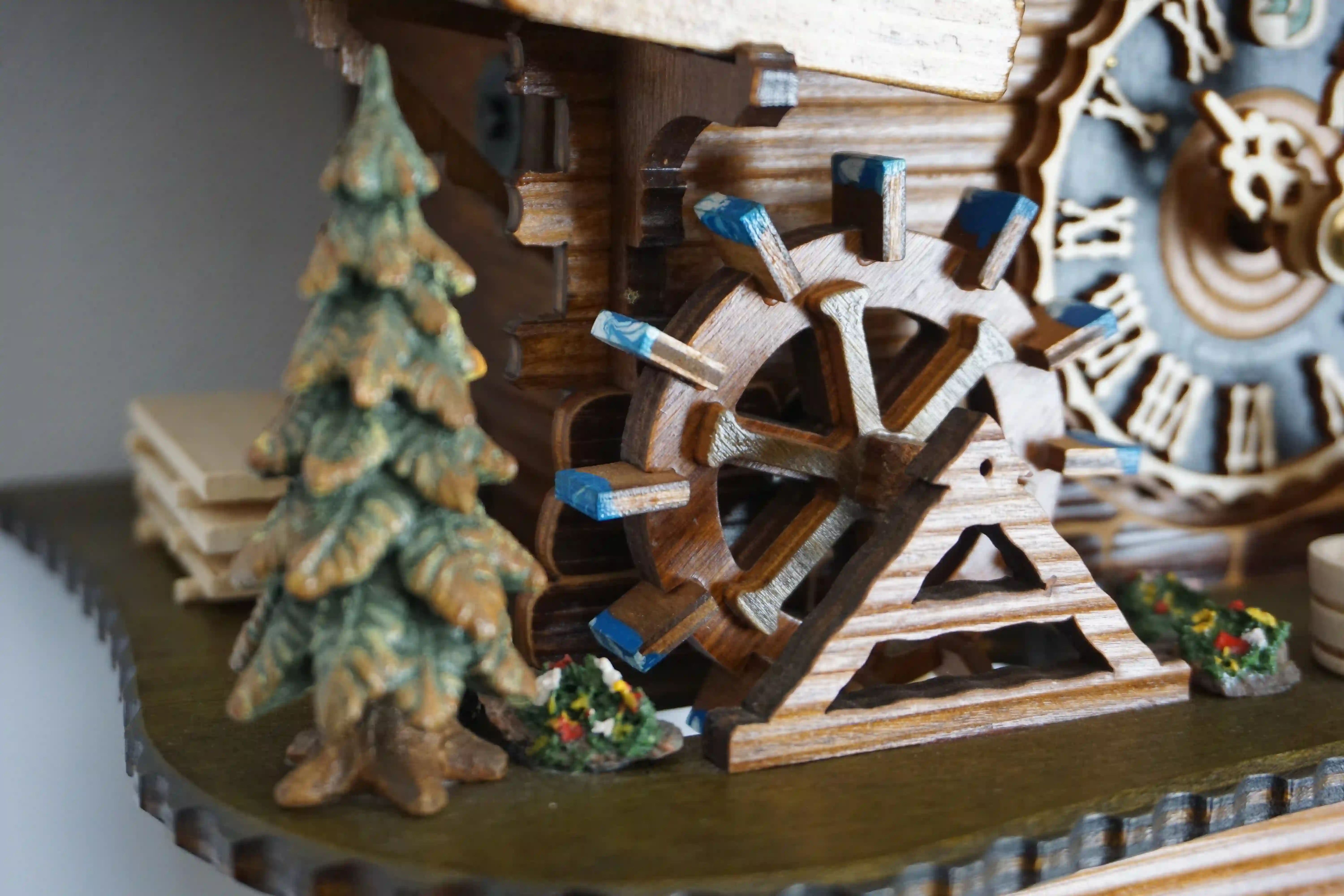 Cuckoo Clock  Bell Ringer Small  1 Day Movement with Music (6) Chalet style authentic mechanical black forest cuckoo clock with shingle roof, church tower bell and black forest lady wearing traditional clothing, the lady rings the bell together with the cuckoo sound, music plays and water wheel turns. This clock has