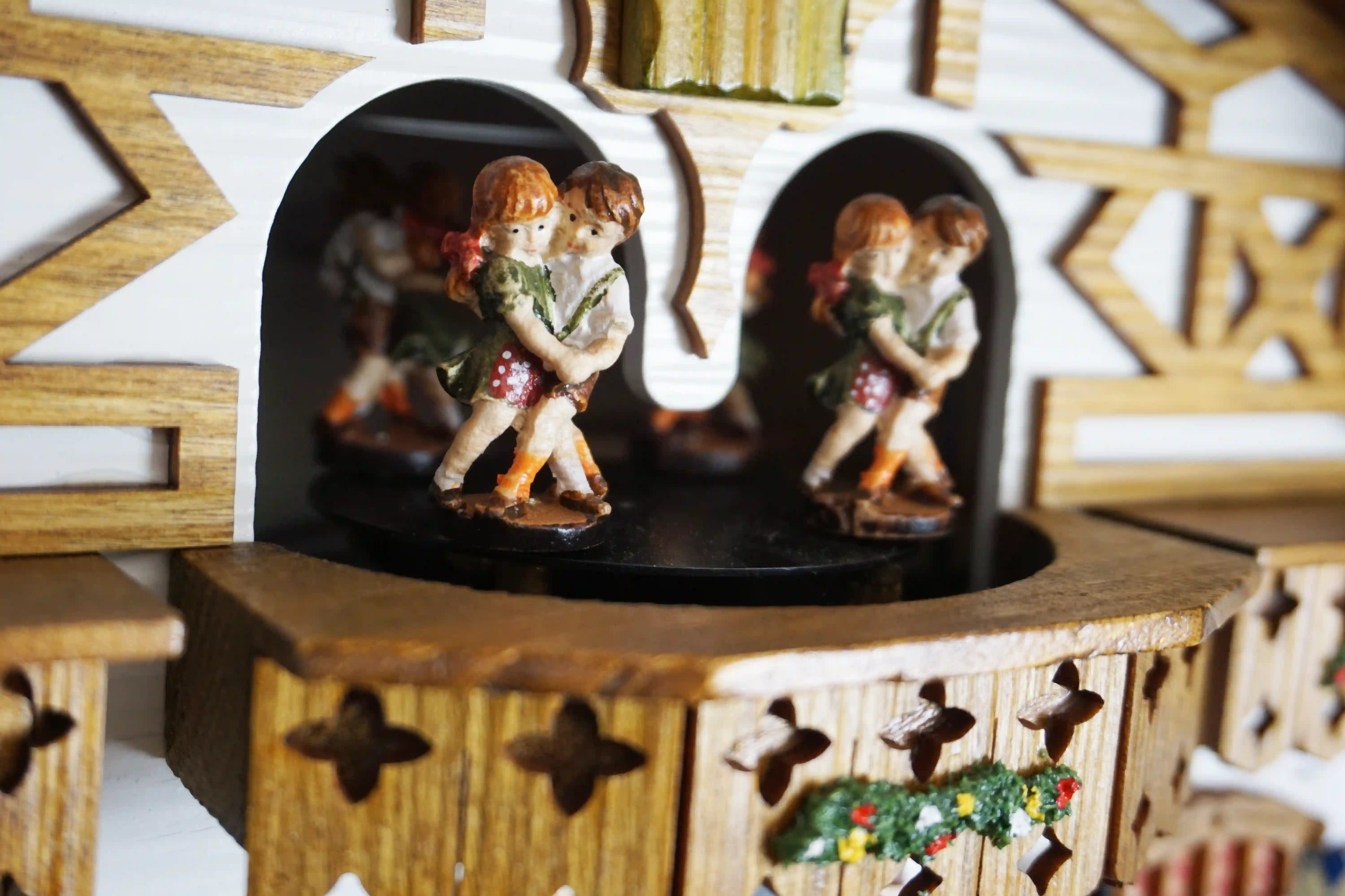 Cuckoo Clock  The Beer Garden  8 Day Movement with Music (7) Bavarian-style house to celebrate the infamous Oktoberfest. Blue and white shutters on the windows represent Bavaria. Around the clock, there are two men drinking beer and a lady wearing a dirndl dress, serving. The cuckoo calls every half hour and plays