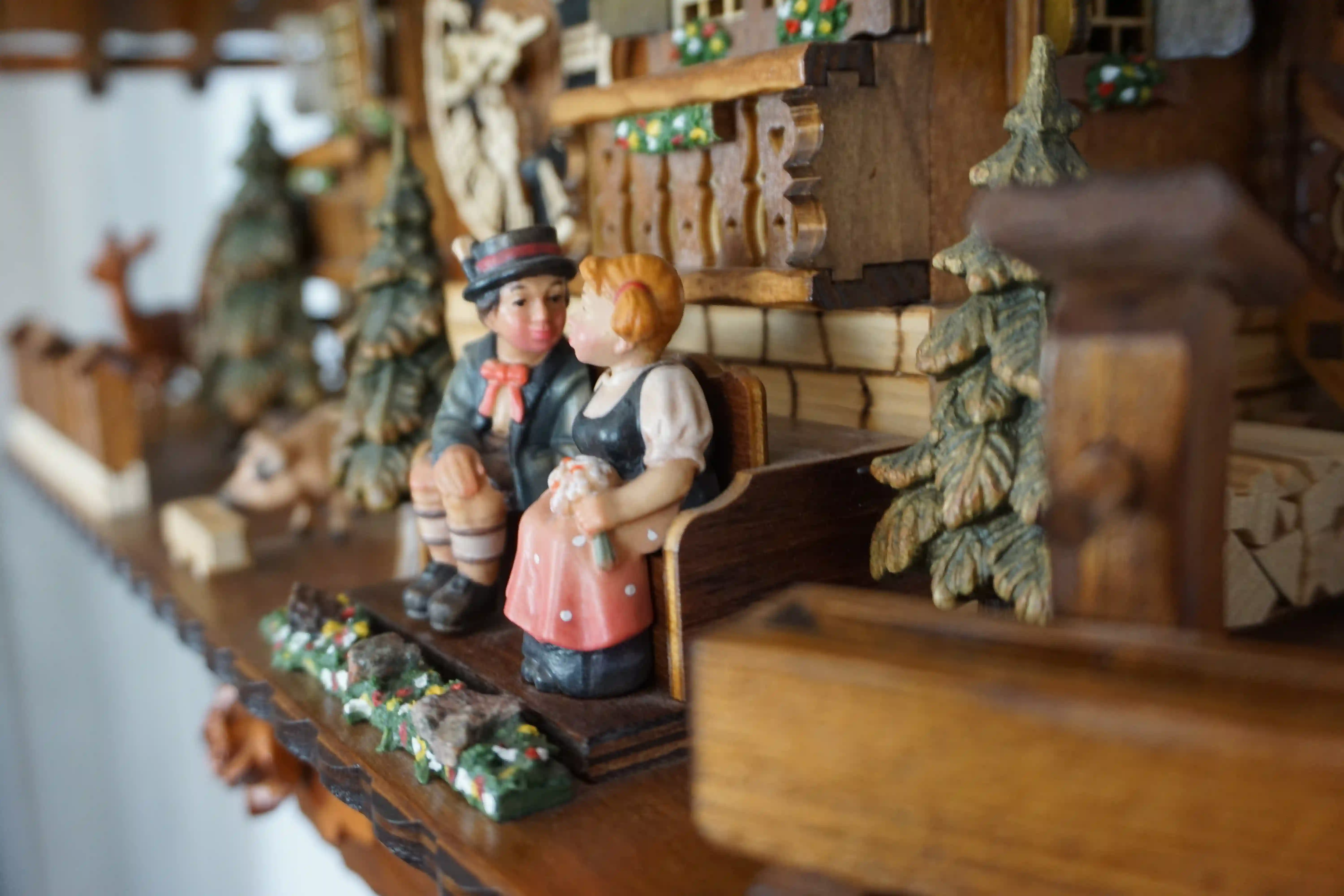 Cuckoo Clock  Honeymoon  8 Day Movement with Music (5) Large authentic chalet colorful black forest cuckoo clocks decorated to the finest detail. Represents a black forest couple on their honeymoon sitting on the bench in front of the shingle roof house. As the music plays the couple is kissing, water wheel t