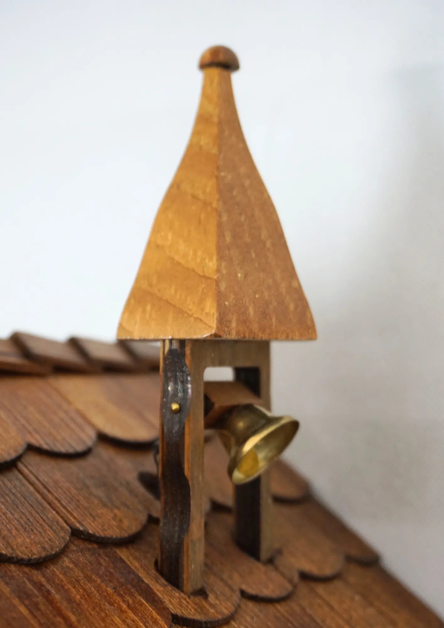 Cuckoo Clock  Bell Ringer Small  1 Day Movement with Music (4) Chalet style authentic mechanical black forest cuckoo clock with shingle roof, church tower bell and black forest lady wearing traditional clothing, the lady rings the bell together with the cuckoo sound, music plays and water wheel turns. This clock has