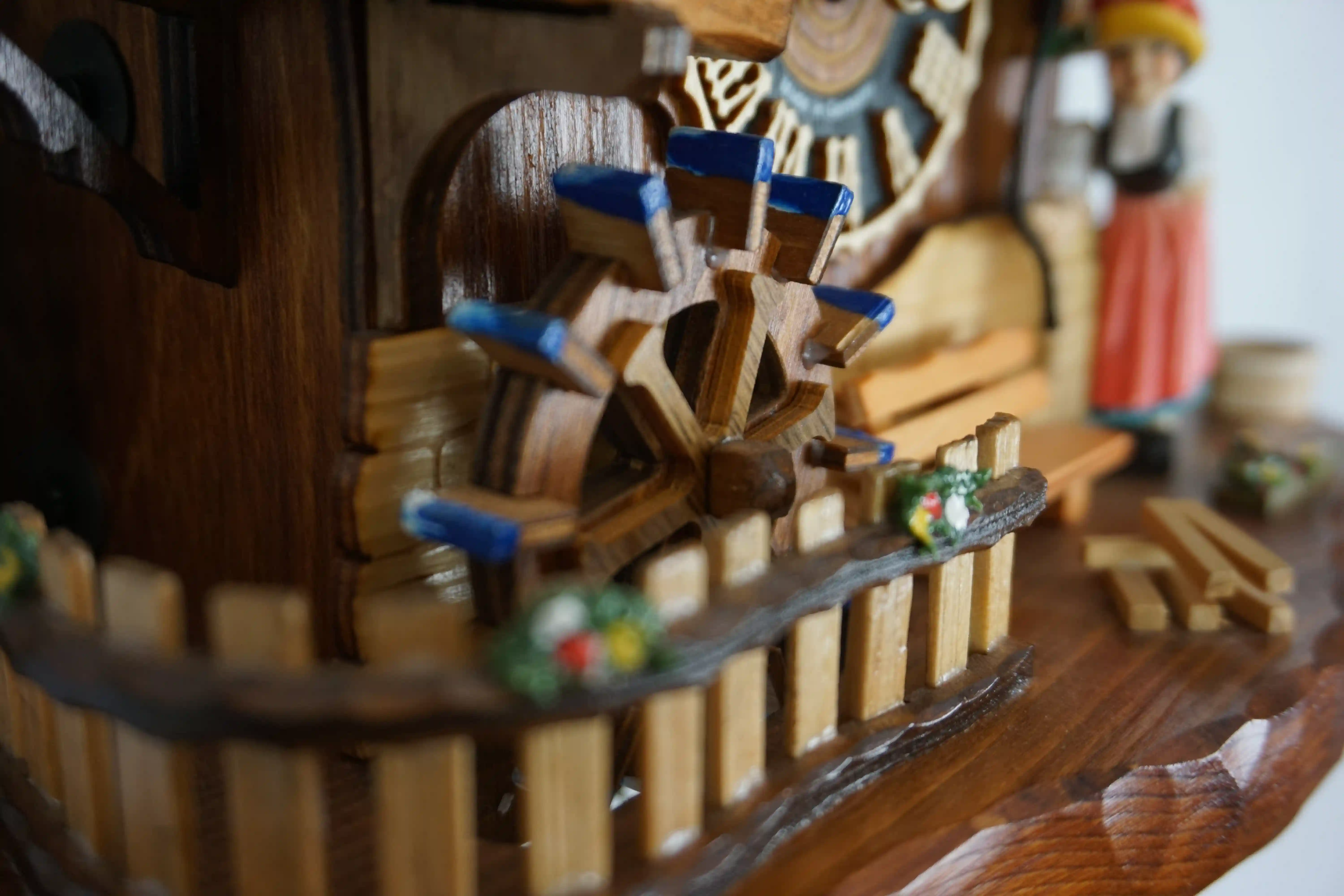 Cuckoo Clock  Bell Ringer  1 Day Movement  Music (5) Chalet style authentic mechanical black forest cuckoo clock with shingle roof, church tower bell and black forest lady wearing traditional clothing, the lady rings the bell together with the cuckoo sound, music plays dancers dance and water wheel turns